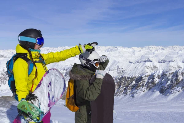 İki genç mutlu arkadaş snowboardcular güneşli bir günde kayak pistinde eğleniyorlar.. — Stok fotoğraf