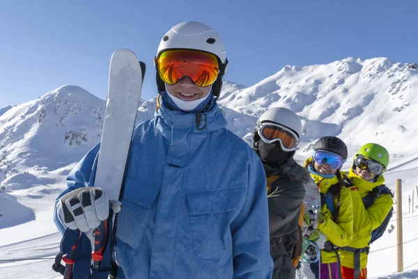 Dört mutlu arkadaş snowboardcular ve kayakçılar kayak pistinde güneşli bir günde kayak ve snowboard yaparken eğleniyorlar.. — Stok fotoğraf