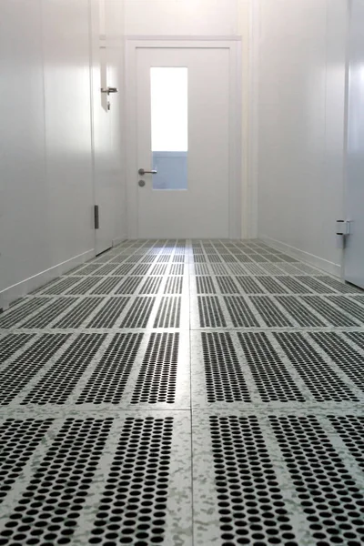 Yarı iletken imalat odasının içinde. Eczacılık ya da elektronik endüstrisi için temizlenme odasının zemin ve kapısı yükseltilmiş bir koridor..