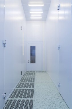 Inside the clean room.Hallway with raised floor and door in cleanroom for pharmaceutical or electronic industry. Double floor for laminar air flow. clipart