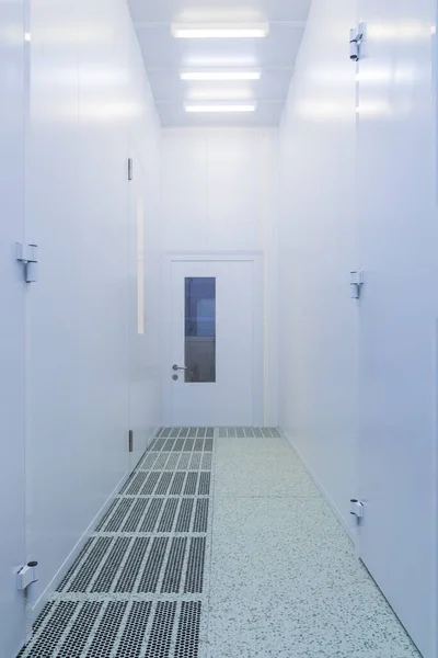 Inside the clean room.Hallway with raised floor and door in cleanroom for pharmaceutical or electronic industry. Double floor for laminar air flow.