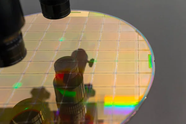 Silicon wafer gold color with microchips on machine process examining in microscope and checking quality . Selective focus .