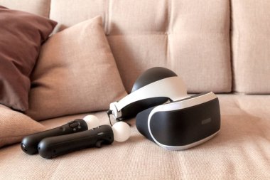Moskova, Rusya - 12 Nisan 2020 Bir Playstation 4 VR kulaklığı ve bir Playstation 4 denetleyicisi ve iki hareket kontrolörüyle birlikte bir kanepede oyuna başlamaya hazır.