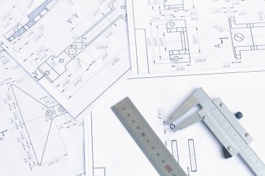 Mühendislik çizimleri, metal parçaları ve kalibre.