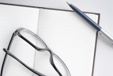 kalem, gözlük ve not defteri