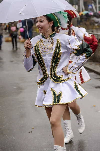 Young majorette smiles under white umbrella at Carnival parade, — Stock Photo, Image