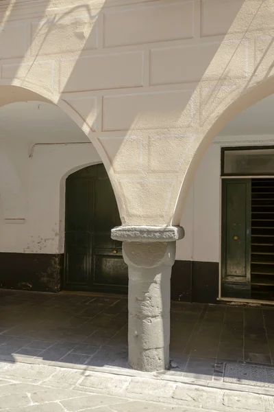 bright light on stone pillar of medieval covered walkway, Chiava