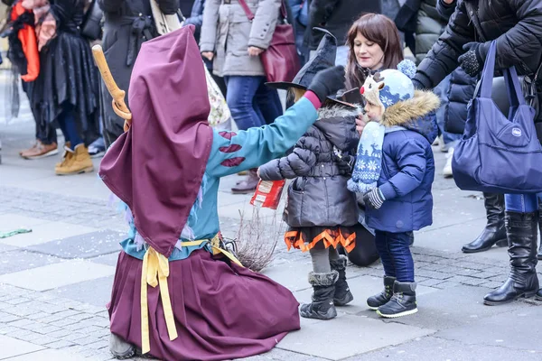 Knelt witch mask plays with childs at Carnival parade, Stuttgart — Stock Photo, Image