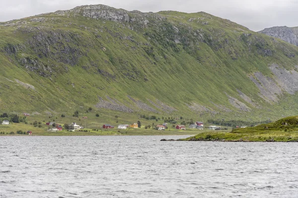 Casas em terra sob encosta íngreme, perto de Bostad, Lofoten, Noruega — Fotografia de Stock