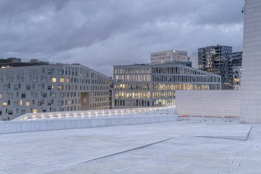 Alacakaranlıkta Opera Tiyatrosu 'nun düz çatısından iş merkezine bakıyorum.