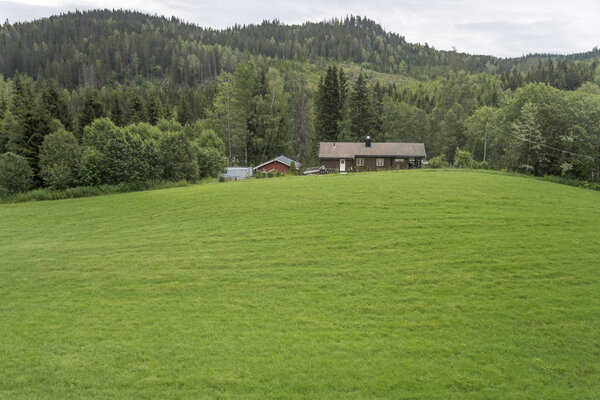 house at the top of meadow in green countryside, near Honefoss, 