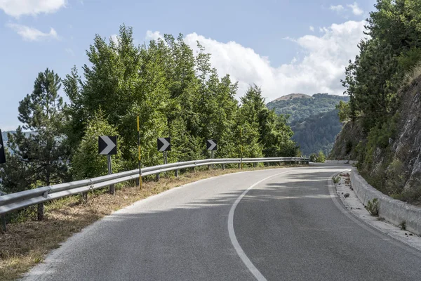 Straße biegt zwischen hügeligen Wäldern, in der Nähe von Paterno, Italien — Stockfoto