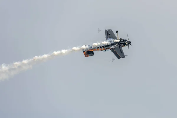 Samolot z czarnym akrobatą wykonujący lot z wywróconym kadłubem na pokazach lotniczych, Włochy — Zdjęcie stockowe