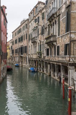 Kanal, Venedik, İtalya 'daki tarihi evlerin altındaki kapalı geçitte masalar