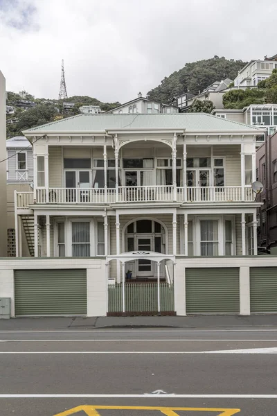 cityscape with picturesque traditional Victorian house loggia at Oriental Parade neighborhood, shot in bright cloudy spring light at Wellington, North Island, New Zealand