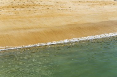 Kum plajı ve Anchorage körfezinde köpük dalgaları Kaiteriteri, Abel Tasman Parkı, Güney Adası, Yeni Zelanda yakınlarında parlak bahar ışığında çekildi.