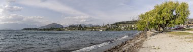 WanAKA, NEW ZEALAND - 22 Kasım 2019: Göl kıyısındaki küçük turistik kasabada dalgalı şehir manzarası, 22 Kasım 2019 'da Wanaka, Otago, Güney Adası, Yeni Zelanda' da çekildi.