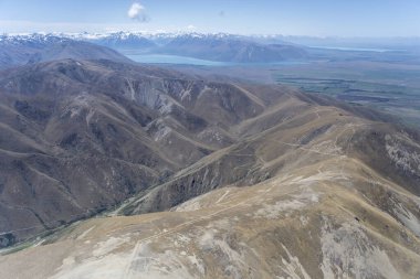 Quailburn, Canterbury, Güney Adası, Yeni Zelanda yakınlarında parlak bahar ışığında çekilen Diadem Sıradağları 'nın verimsiz yamaçlarından ve Ahuriri nehir vadisinden