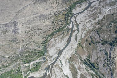 Gökyüzü, Pukaki nehir yatağından, kıraç topraklardaki balık sürülerinin kıvrımlarıyla, yukarıdan çekilen parlak bahar ışığında, Canterbury, Güney Adası, Yeni Zelanda