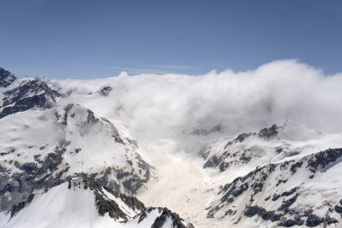 Doğudan Canterbury, Güney Adası, Yeni Zelanda 'dan parlak bahar ışığı altında çekilen Murchinson buzulu ve bulut perileri ile planörden çekilen hava.