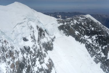 Bir planörden, kayalık kayalıklardan ve dağdaki kar heyelan dağlarından. Aşçı sırtı, kuzeybatıdan parlak bir bahar ışığı ile vuruldu Canterbury, Güney Adası, Yeni Zelanda