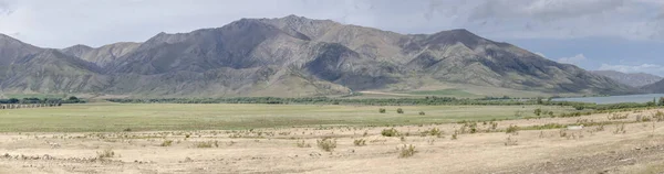 landscape with flat fields and barren slopes near Benmore lake in green valley, shot in bright spring light from west, Canterbury, South Island, New Zealand