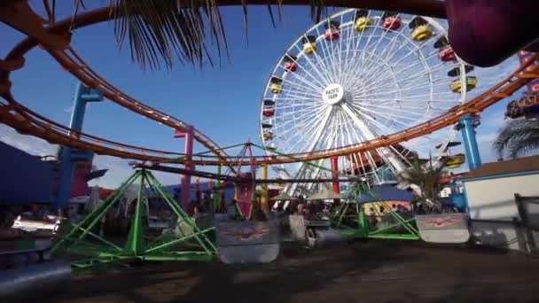 SANTA MONICA, EUA - 19 de junho de 2016: Pessoas nos passeios no Pacific Amusement Park, em Santa Mônica, Califórnia. O parque está hospedado no cais, um marco histórico de mais de cem anos . Vídeo De Stock Royalty-Free