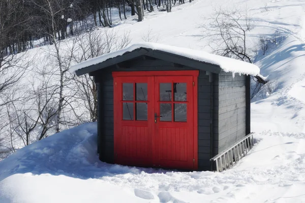 Vivid red hut on snow covered mountain in winter — Stock Photo, Image