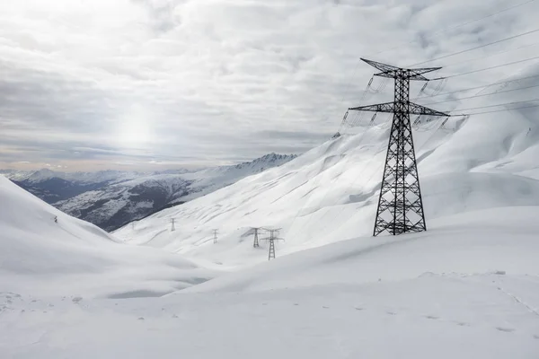 Paysage hivernal blanc dans les montagnes enneigées, tours haute tension — Photo