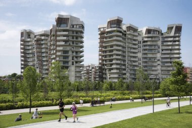 İnsanlar rahatlatıcı ve Milan Citylife soka yeşil alanda fitness yapıyor