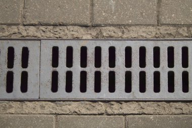 Yukarıdan görüntüleyin. Eski paslı rendeleyin kaldırımda drenaj