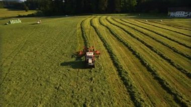 Anteni traktörün saman sahada yeşil hat güneşli bir günde 4 k dağlarında toplar