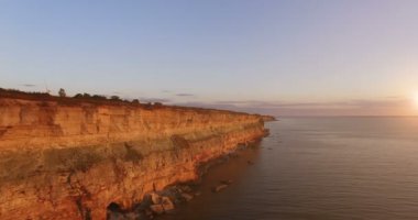 Gün batımında deniz korkunç taşlarla uçurumun havadan görünümü