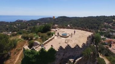 Kalenin üzerinde hava görünümünü turist ile eski bir mimari yapının. Ulusal bayrak kalesinde sallıyor. İspanya, Katalonya, Begur Castle