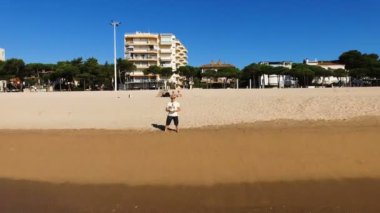 Deniz kenarı vericisi ile kontrol uçağı adamım. Bir dron kullanarak areial bir fotoğraf operator yapar