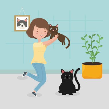 Kahverengi kedi ve siyah kediyi elinde tutan kadın evcil hayvan bakımında oturuyor.