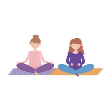 Evde kal, kızlar minderde yoga meditasyonu yapıyor.