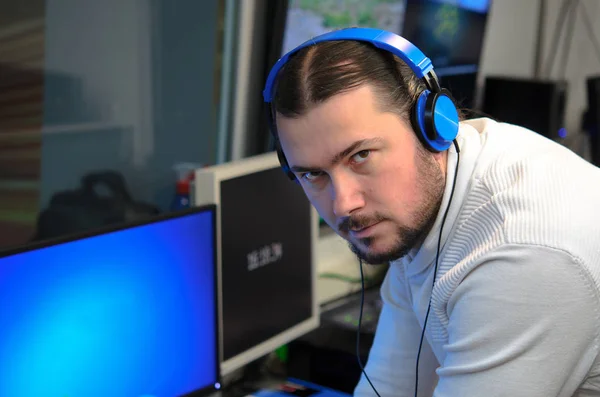 Editor de transmissão de vídeo com fones de ouvido assistindo uma ação no — Fotografia de Stock