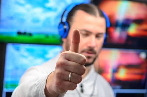 Editor de transmissão de vídeo com fones de ouvido assistindo uma ação no — Fotografia de Stock