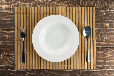 Paslanmaz kaşık ve çatalı bambu örgü ile beyaz boş yemek bir
