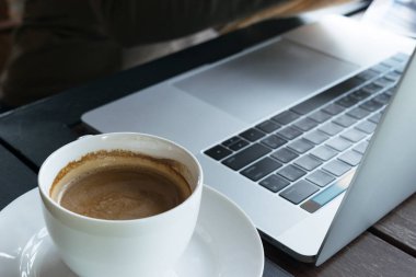 Tablo ahşap arka plan kafede kahve ve bulanıklık laptop