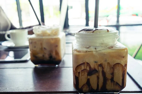 Kopi, es kopi di meja kayu latar belakang di kafe, di depan o — Stok Foto