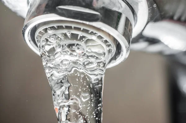 Corriente de agua congelada de un grifo Primer plano. Funcionamiento del aireador para s — Foto de Stock