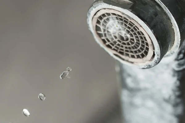 Damlayan bir damla suyla musluk sızdırmak. Su tesisatını ara.