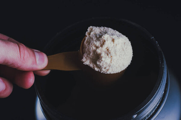Sports Nutrition Powder. Soluble protein in a measuring spoon in