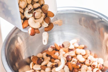 Pour hazelnuts, almonds, cashews and a walnut in one bowl with c