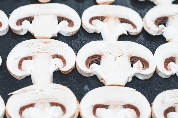 Porcini champignons worden in plakjes gesneden op een grijs stenen oppervlak. Bac — Stockfoto