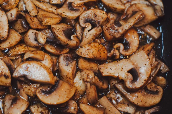 Porcini mushrooms cut into slices are fried in seasoning with pe — Stock Photo, Image