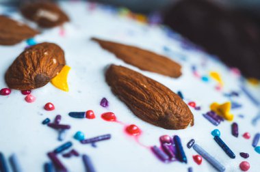 Çok renkli çubuklar ve toplar serpiştirilmiş fındık bademlerinin yanında beyaz jöleli..