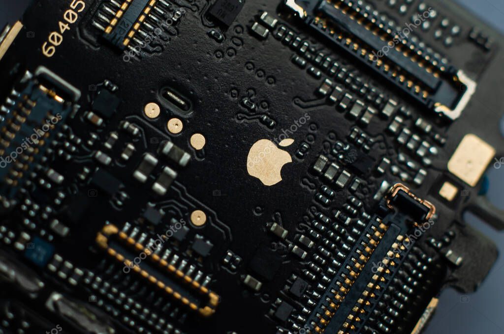 Kiev, Ukraine - May 6, 2020: Close-up of a first generation iphone se motherboard. Engraved golden apple.